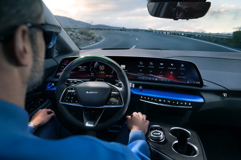 Front View of the 2026 OPTIQ-V Driving Through the Dusk Utilizing its Headlights | Moses Cadillac of Charleston in Charleston WV